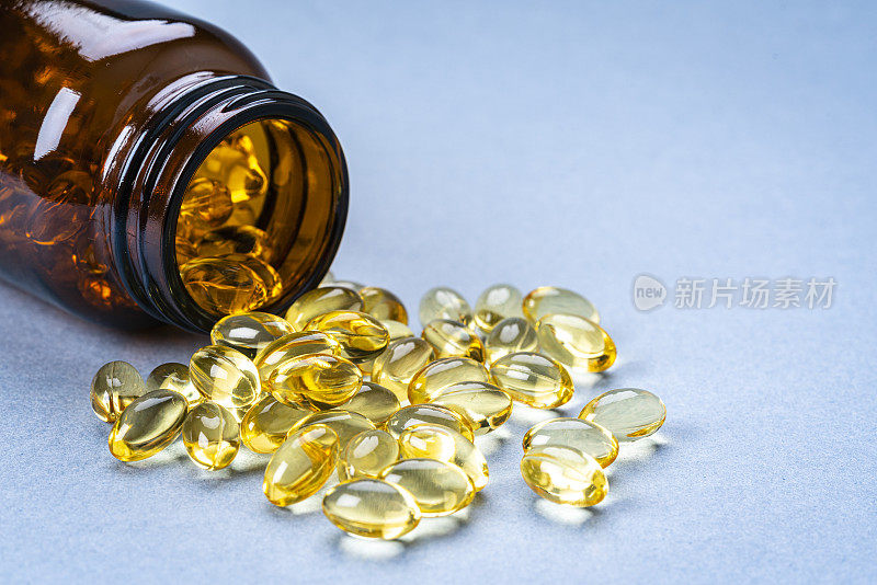 Omega - 3或营养补充药片从瓶中溢出